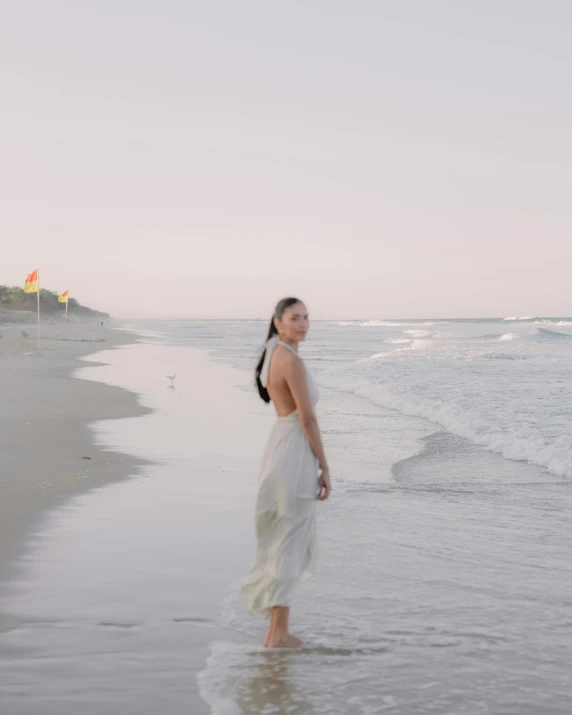 woman in white dress on the beach in a body of water