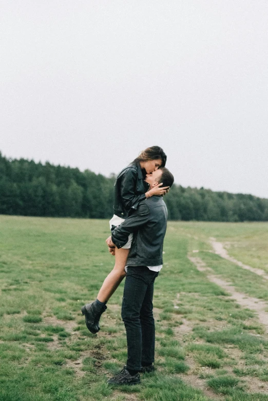 a woman is carrying a man across a field