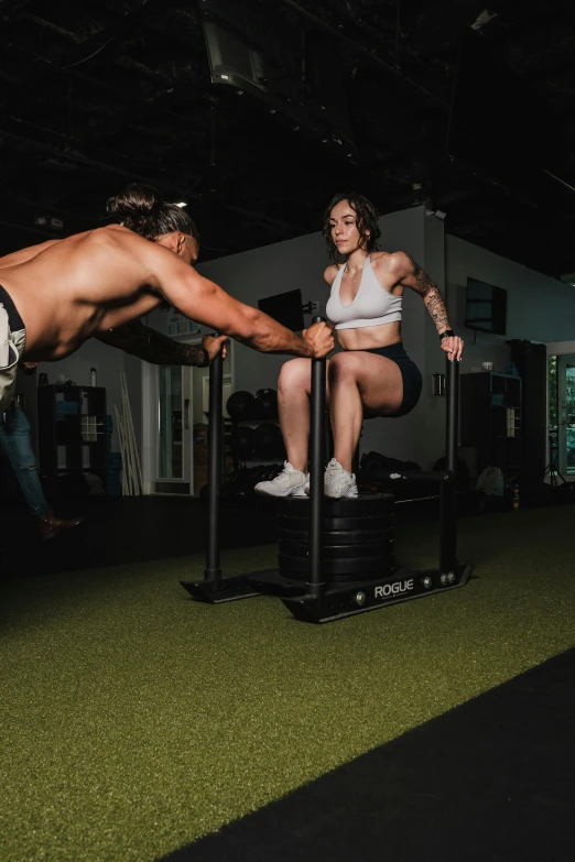 woman in shorts and white shirt is on a treadmill with another woman