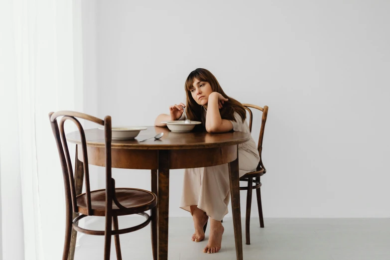 a woman sitting at a table with a plate in her hands