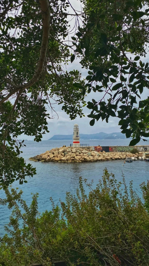 a lighthouse sitting next to the ocean and some water