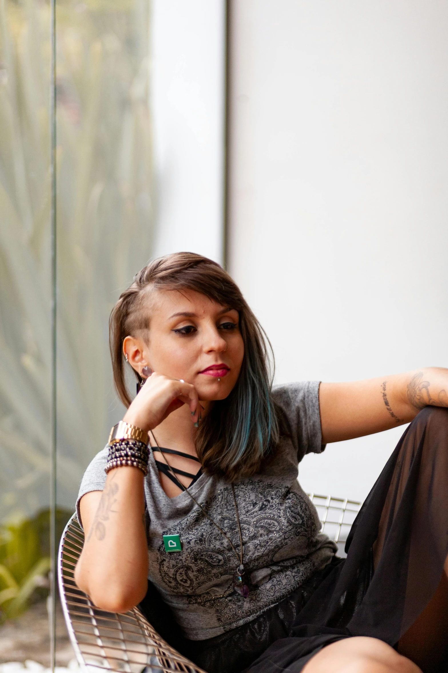 a young lady sitting on top of a chair with her hands resting her face