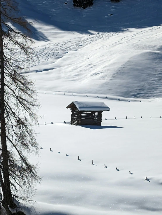 an old shack sitting on a snow covered hill
