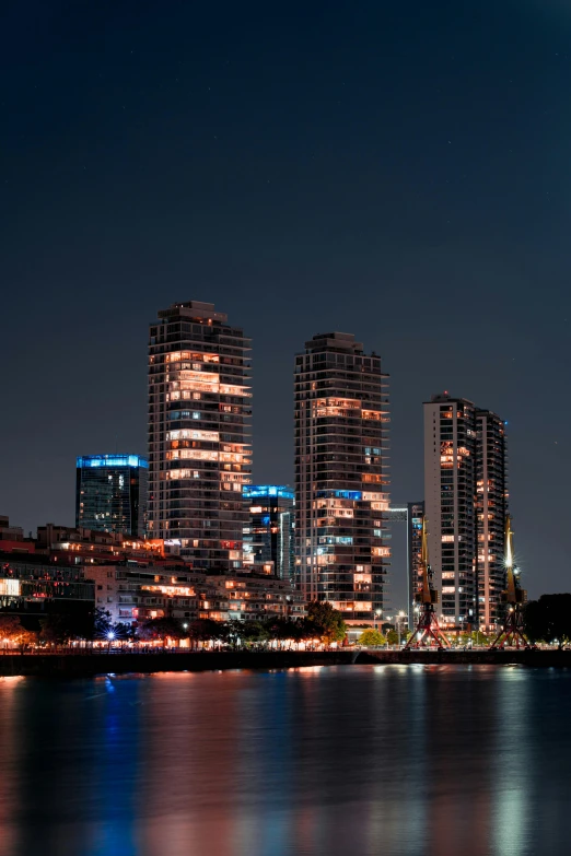 city skyline at night reflecting in the water