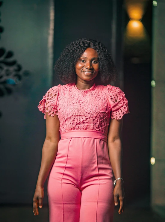 an african american woman is posing for the camera in pink pants