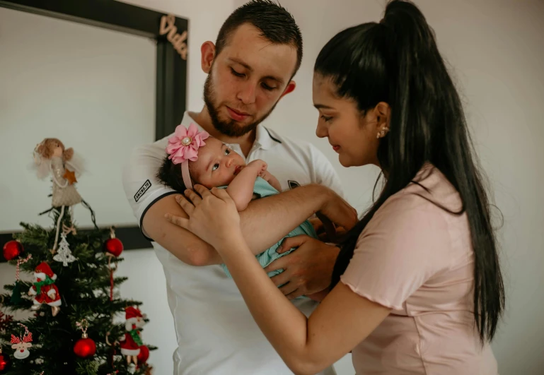 an adult and child are looking at the baby in the arms of the woman