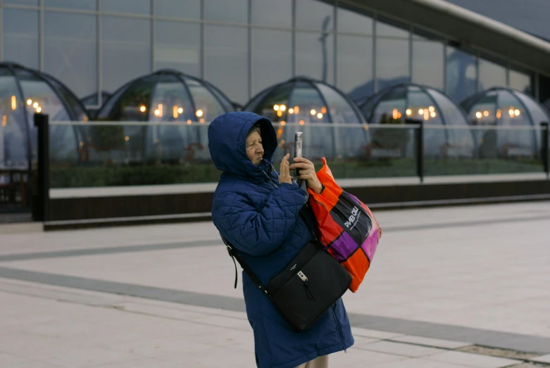 a woman using a cell phone in front of some buildings