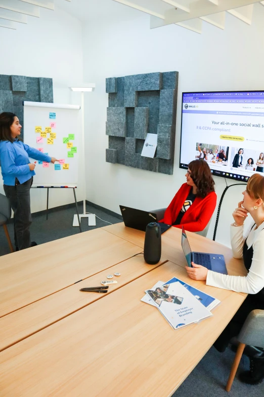 three people are sitting around a conference table