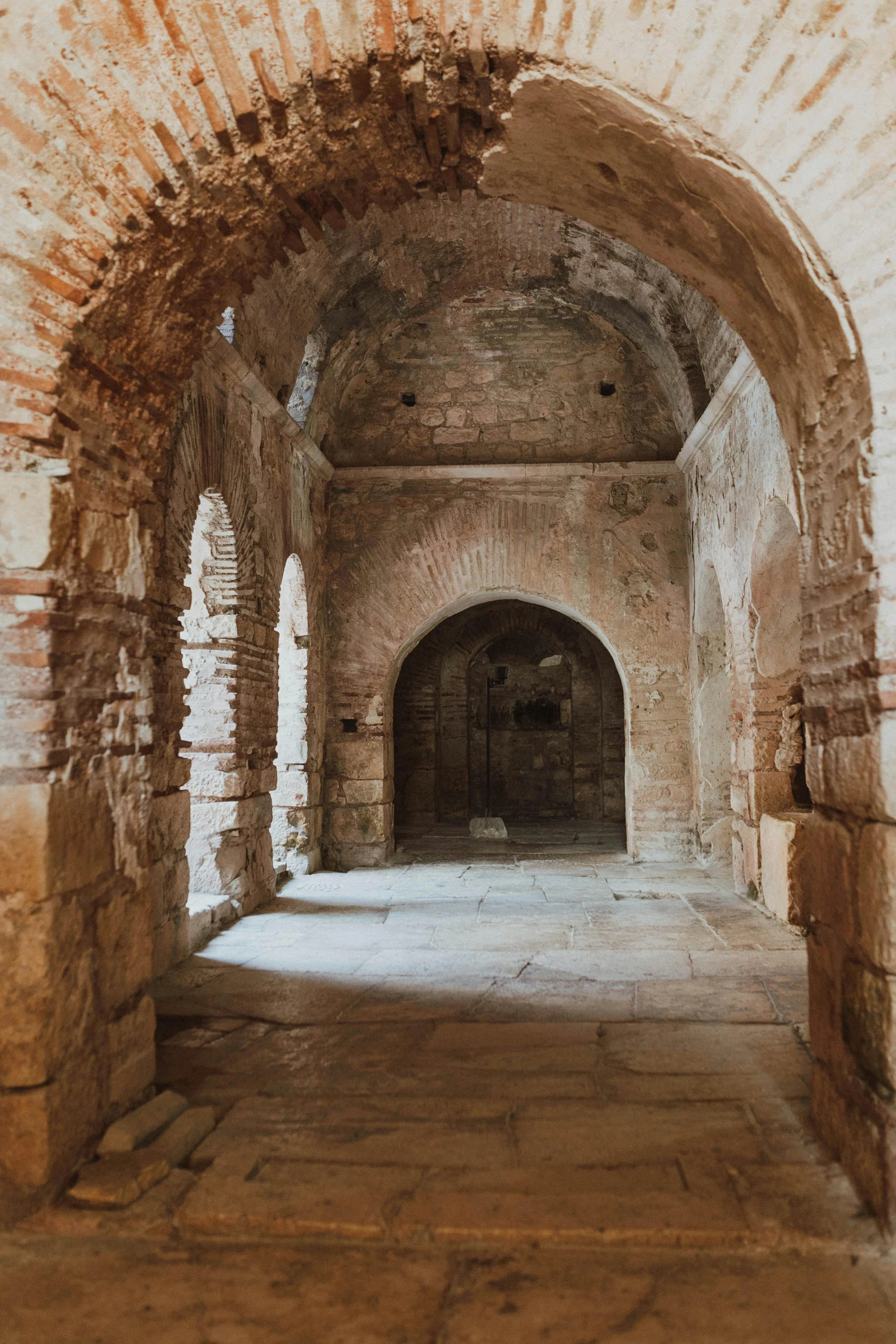 an old hallway is made with brick and stone arches