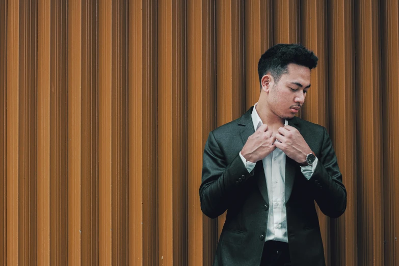 man standing in front of a wooden wall in an auditorium