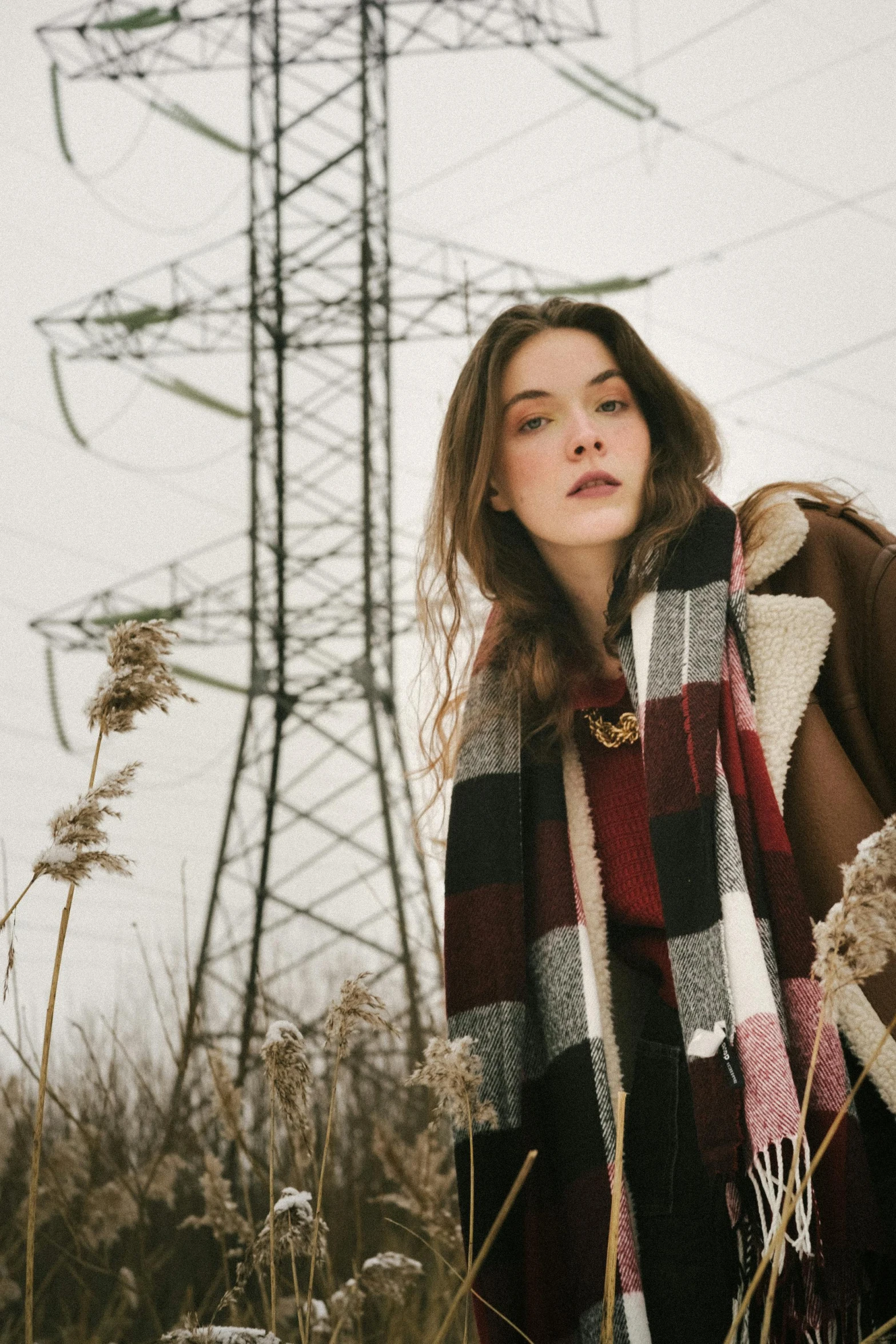 a woman in a large blanket standing by a tower