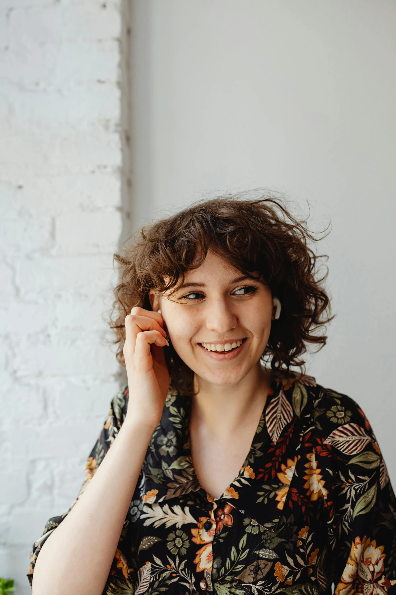 a woman is smiling with a black flower blouse on