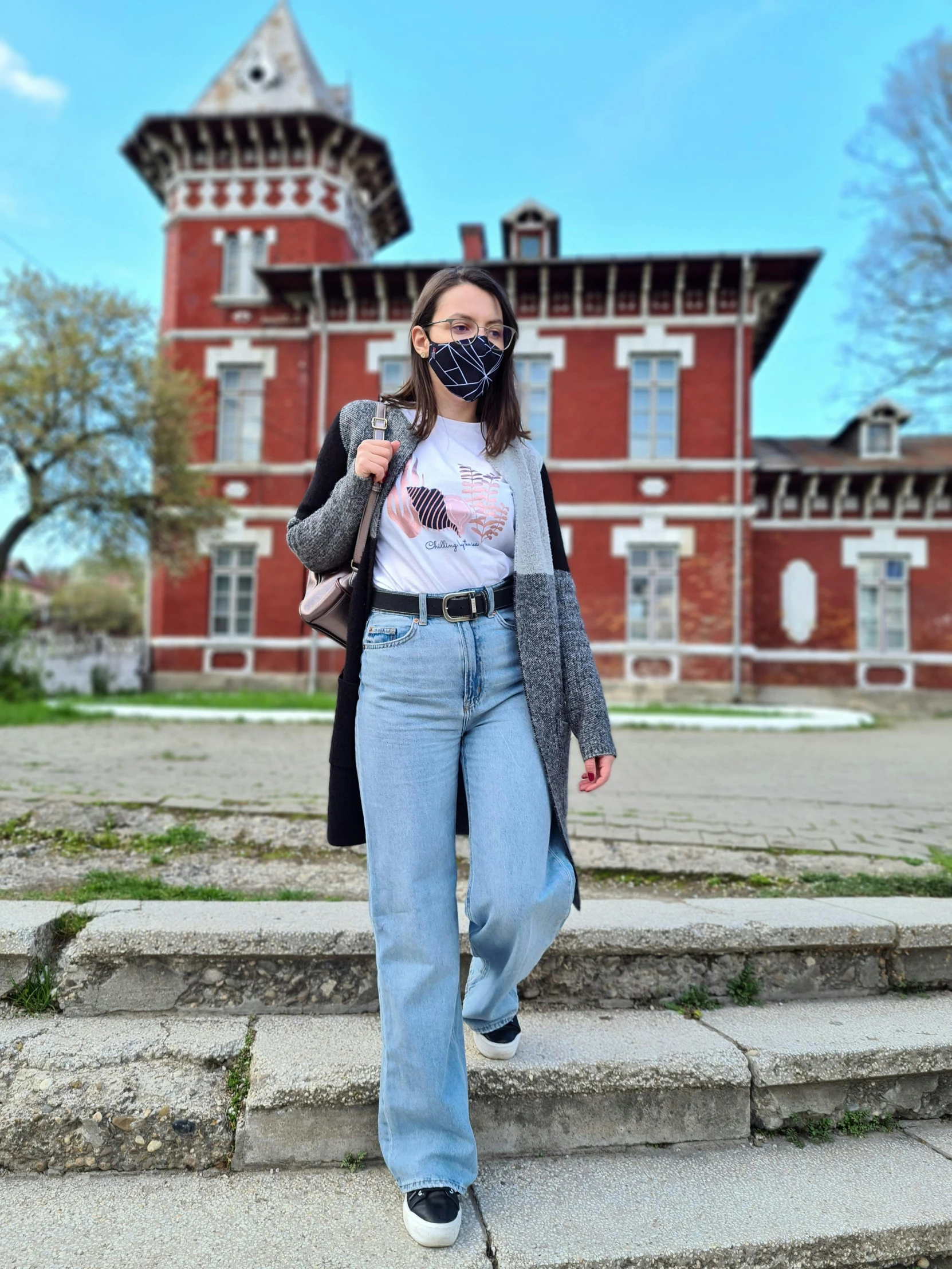 the young woman is walking down the steps wearing a face mask