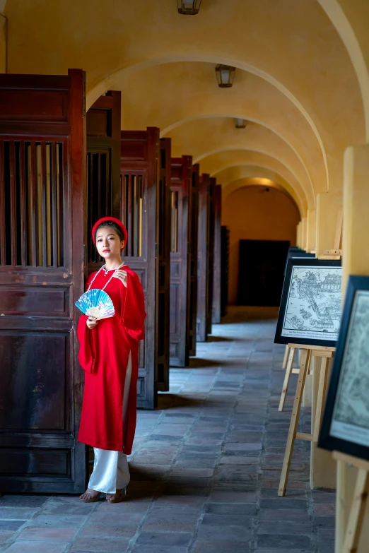 woman in red dress standing in hallway with long doorway