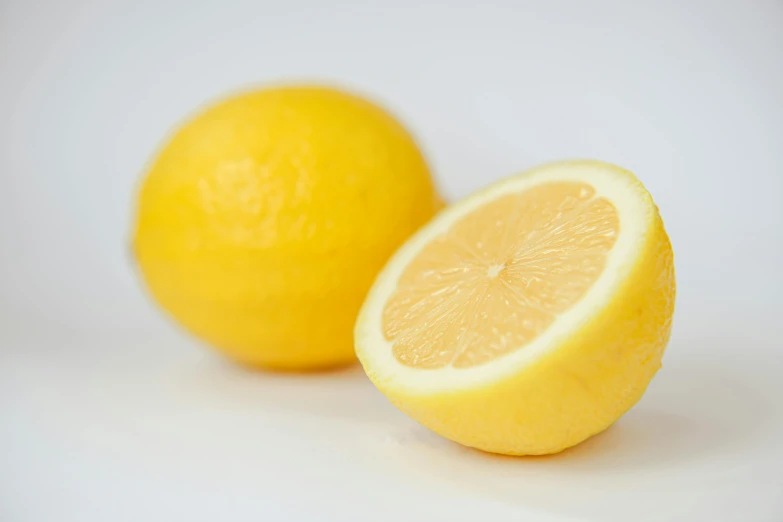 a sliced lemon and a whole gfruit sit together