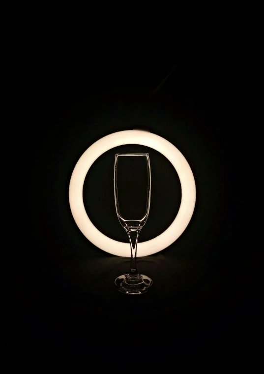 a glass is illuminated in the dark by an orb light