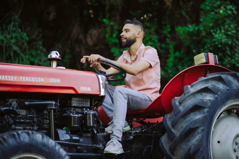 man driving a tractor with red seat