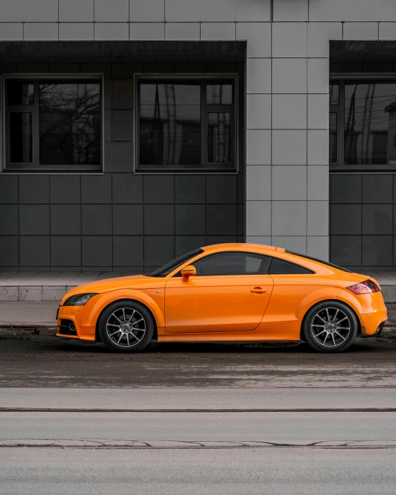 a orange car is parked on the side of a road