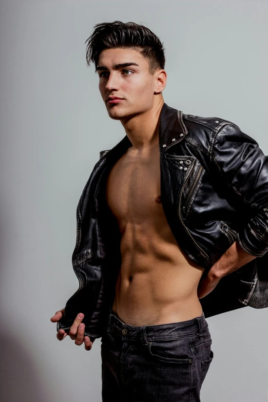 the shirtless young man wears a black leather jacket