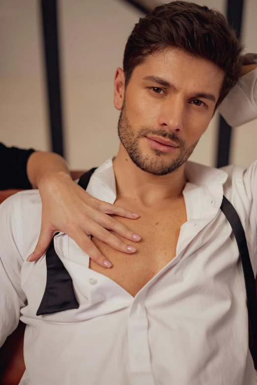 man in white shirt holding hand over chest