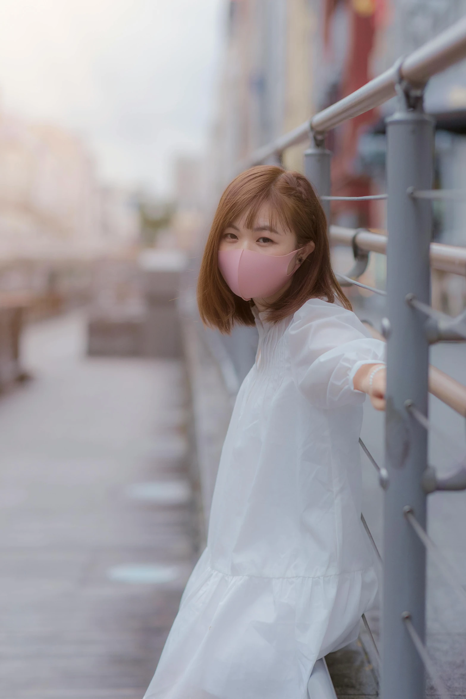 an asian young woman standing next to a wall