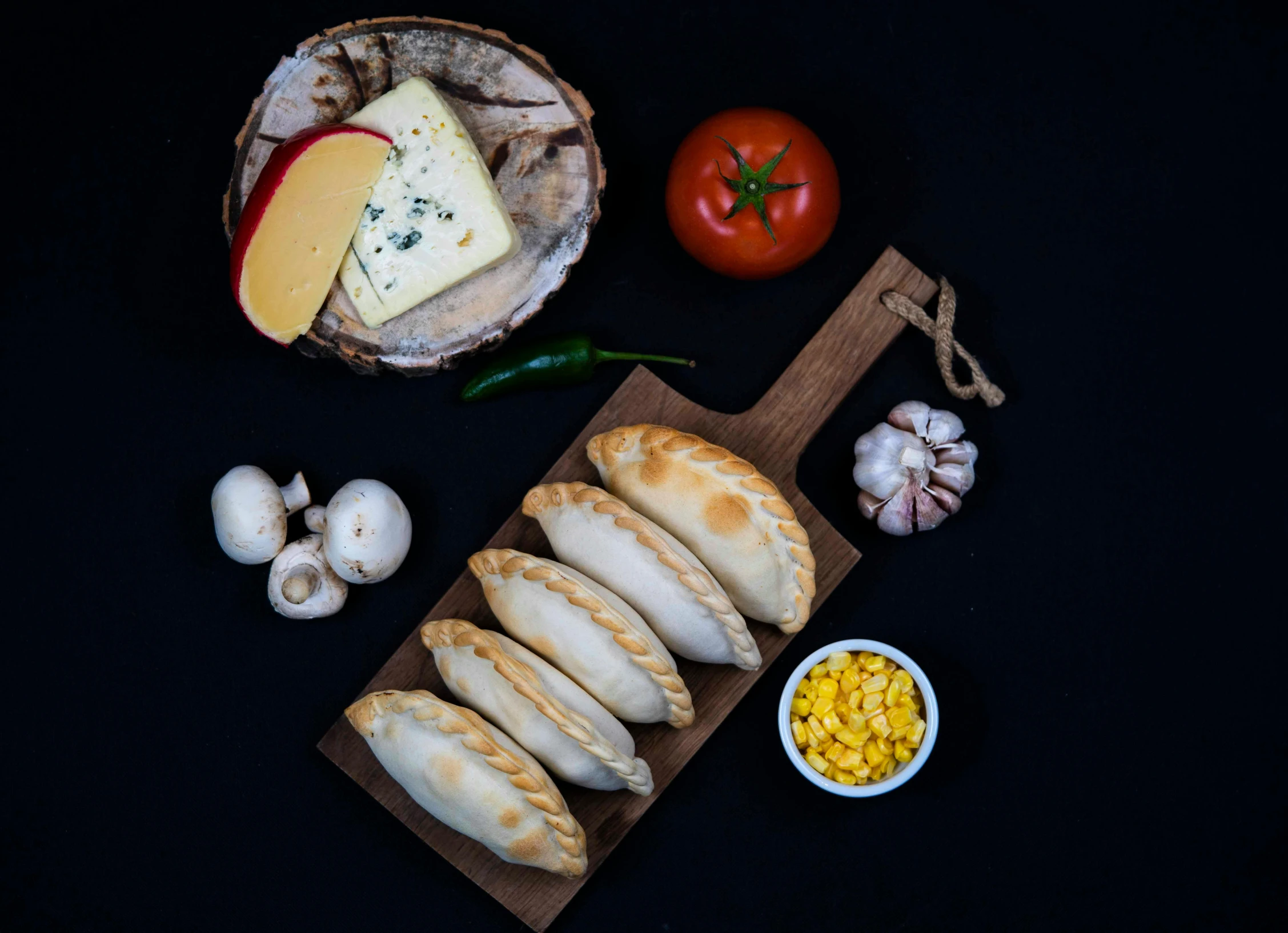 a group of breads sitting on top of a table next to vegetables