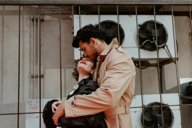 a man holds his head and is comforted by the back of a woman