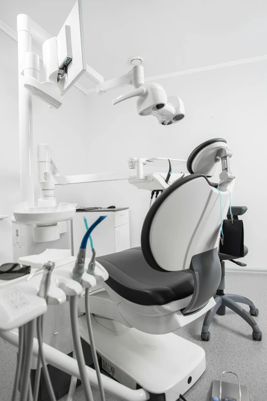 a white dentist chair and desk with microscope