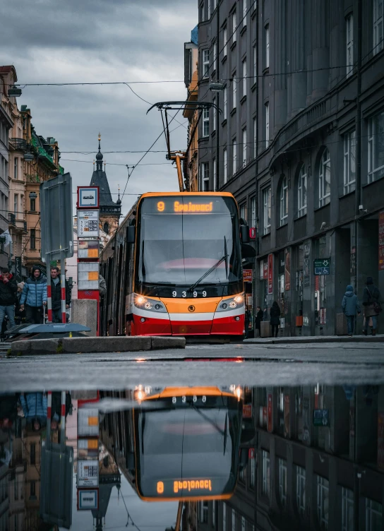 a red and yellow bus is driving down the street