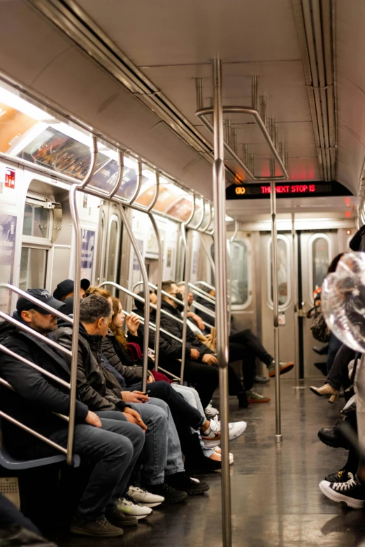 people on the subway are sitting in the same row