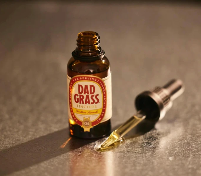 a bottle of fathers day medicine sits on the ground with a small pen on top of it