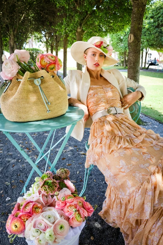 a woman in hat sitting on chair next to a table