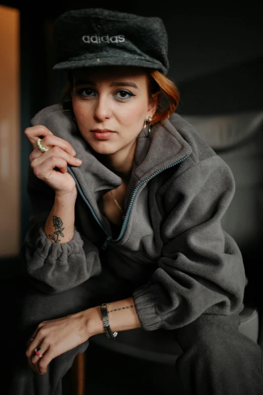 young woman in grey outfit sitting on wooden floor