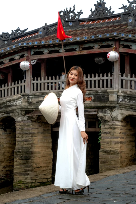 a woman is in an oriental style dress and hat