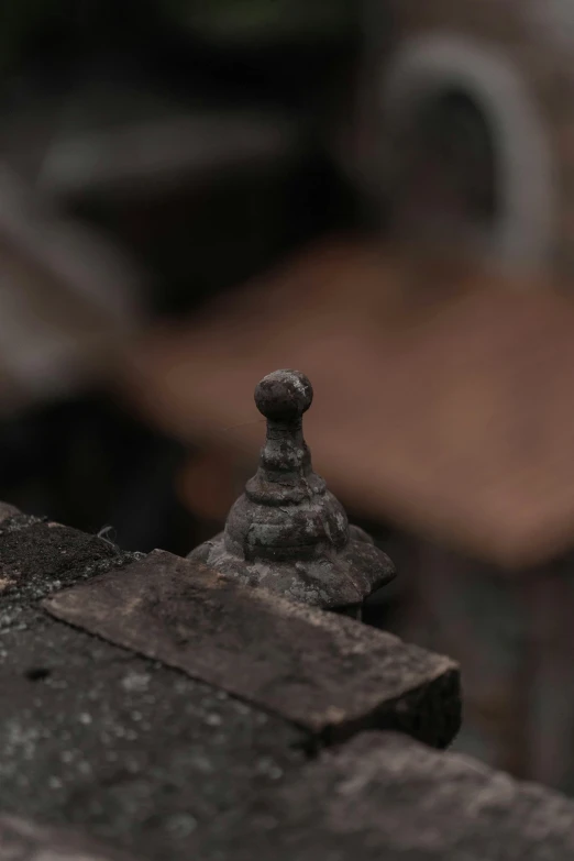 the corner of an old building with a sculpture of a piece of wood sitting on top of it