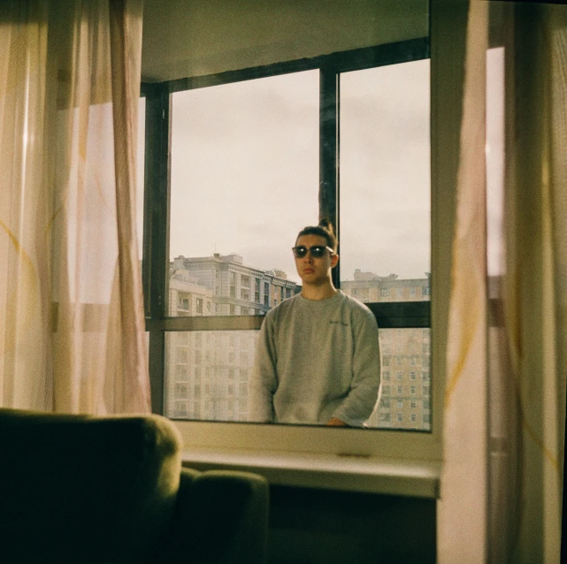 a man with sunglasses looks out a window