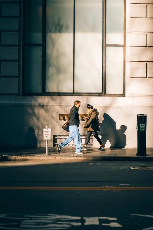 a person walking past a tall building near a bench