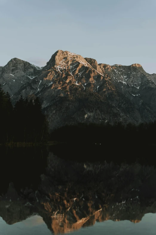 a mountain reflection on a lake with snow on top