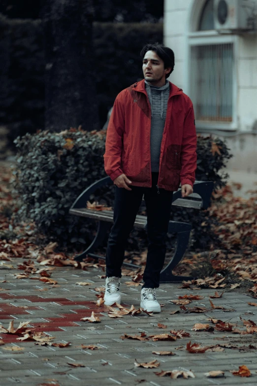 a man stands in the street covered with leaves