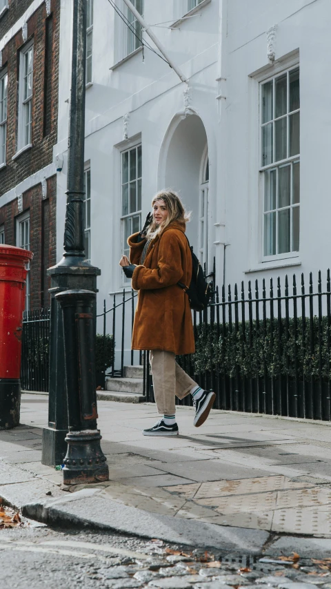 a woman standing outside near a street lamp