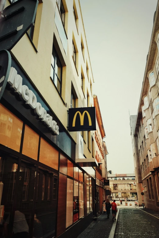 a mcdonalds sign hanging from the side of a building