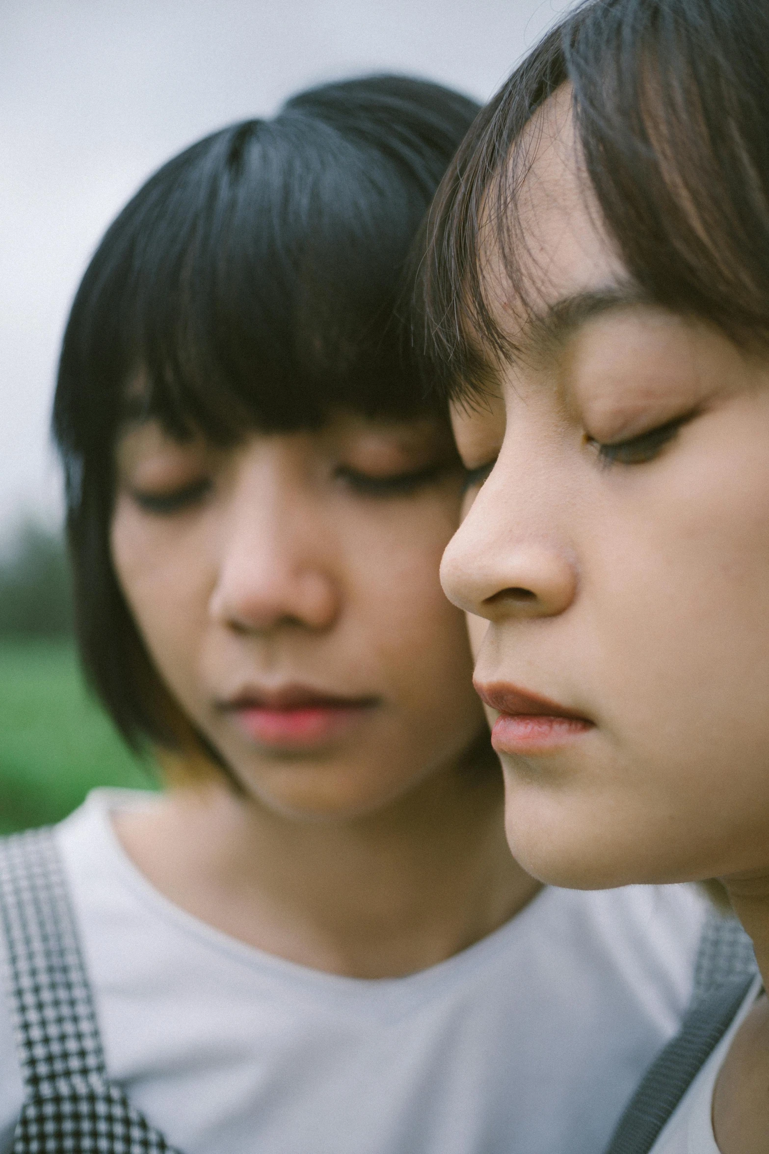 two asian girls looking at a cell phone