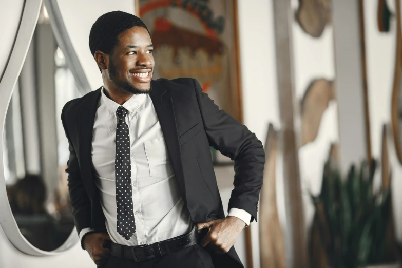 an african american man wearing a black suit, tie and white shirt