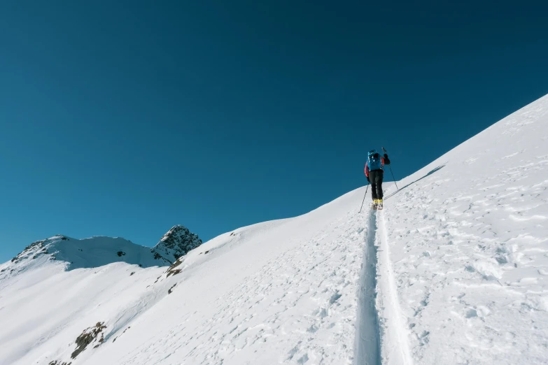 people riding down the side of a snowy mountain