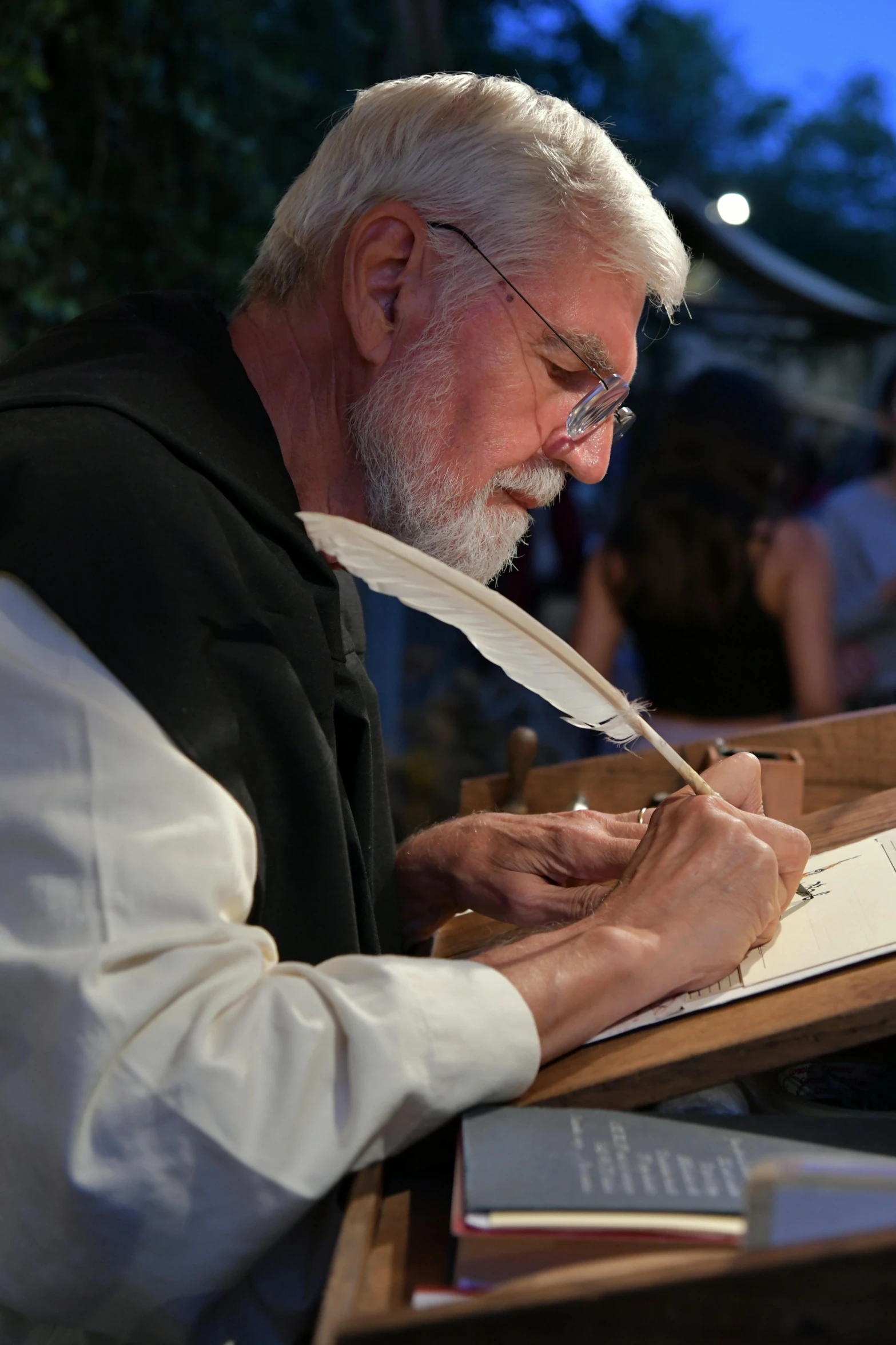 an older man sitting in a chair writing soing