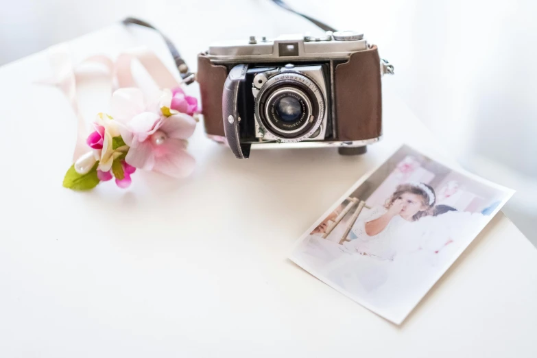 an old camera is sitting next to some flowers