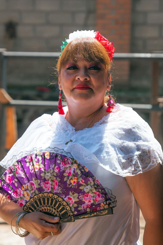 woman in traditional dress holding a pink fan