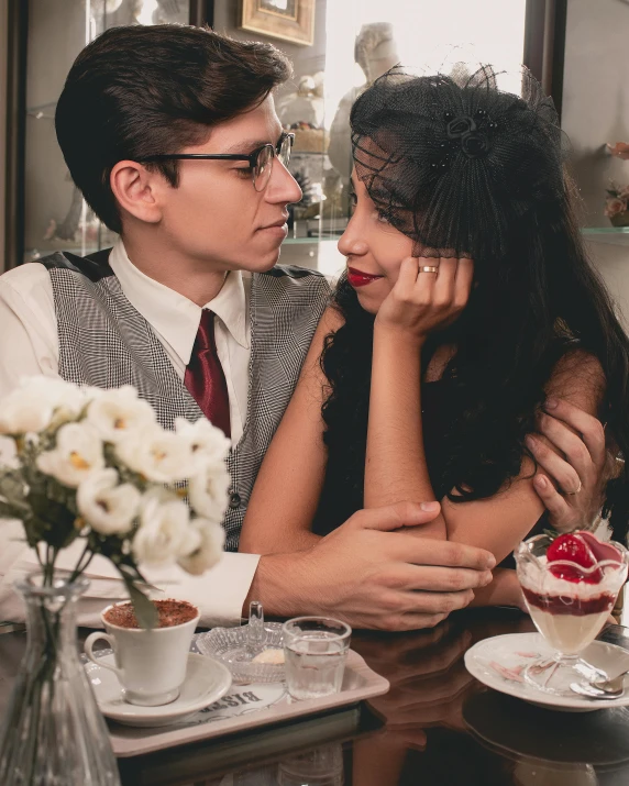 the man and woman are sitting at a table looking into each others eyes