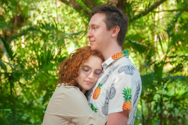 the girl and the man are hugging near some trees