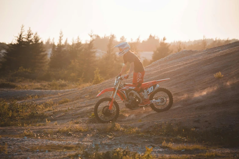 a boy riding on the dirt bike in a field